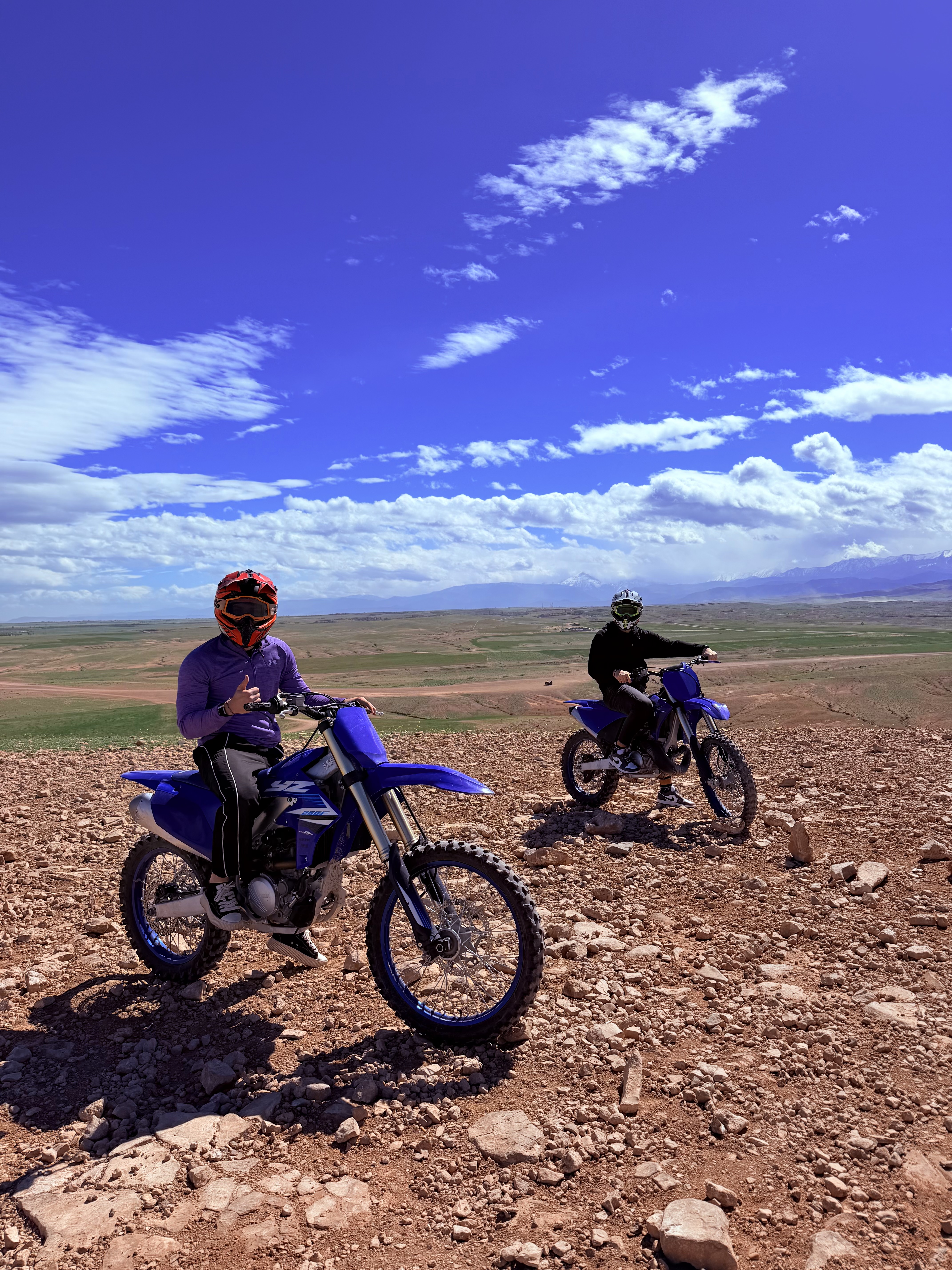 Deux pilotes en moto cross Yamaha YZ sur un plateau face à l'Atlas